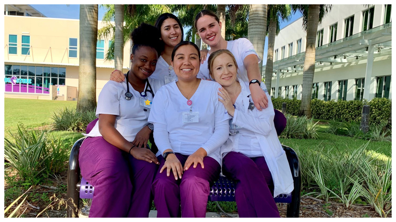 Five FSW Nursing Students gathered around a bench on campus